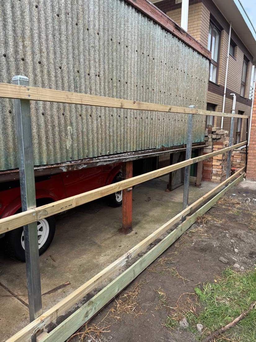 Galvanised steel posts and timber rails mid-build on an Indented Head boundary fence