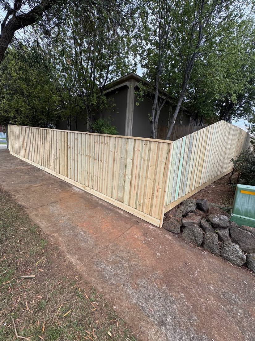 Capped timber paling fence stepped along a corner-block frontage in Grovedale